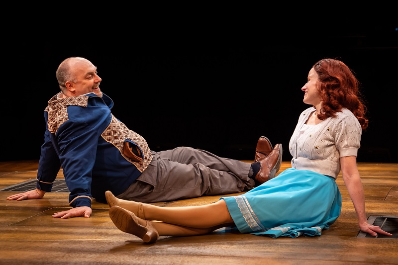 Edward Bloom and Sandra Bloom sitting on a wooden floor in Big Fish from Marriott Lincolnshire Theatre