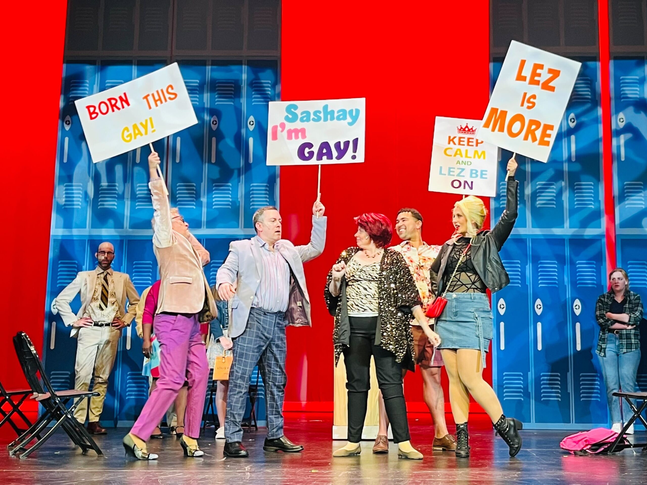 Corey Mills, Robin Trevino, Christine Pfenninger, Elijah Warfield, and Jessica Means in 'The Prom' holding signs at a protest